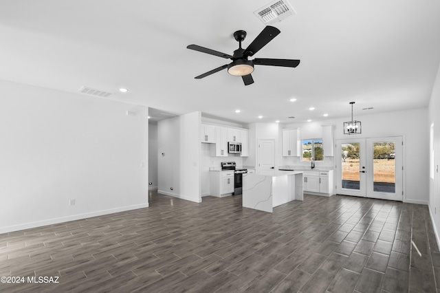 unfurnished living room with french doors, dark hardwood / wood-style flooring, and ceiling fan