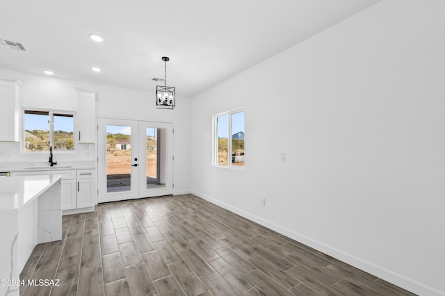 unfurnished dining area with french doors, hardwood / wood-style flooring, a wealth of natural light, and sink