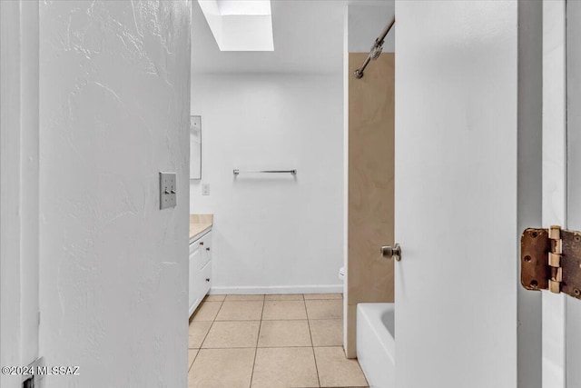 bathroom featuring tile patterned flooring, vanity, toilet, and a skylight