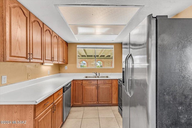 kitchen with light tile patterned floors, stainless steel appliances, and sink