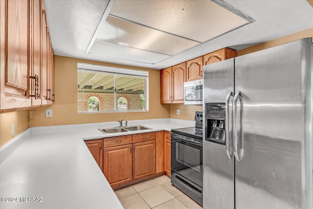 kitchen with sink, light tile patterned flooring, and appliances with stainless steel finishes