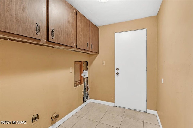 laundry area featuring cabinets, electric dryer hookup, and light tile patterned flooring