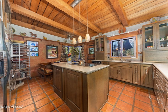 kitchen with beam ceiling, sink, wooden ceiling, decorative light fixtures, and a center island with sink