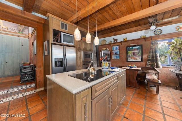 kitchen featuring beamed ceiling, decorative light fixtures, a kitchen island, and stainless steel appliances