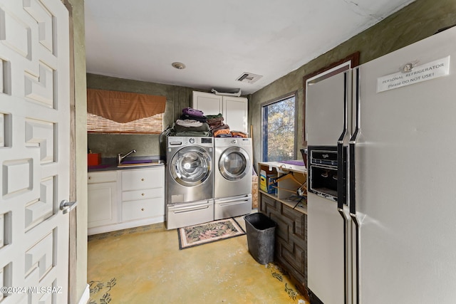 washroom featuring washer and clothes dryer, cabinets, and sink