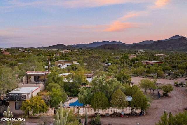 aerial view at dusk featuring a water and mountain view