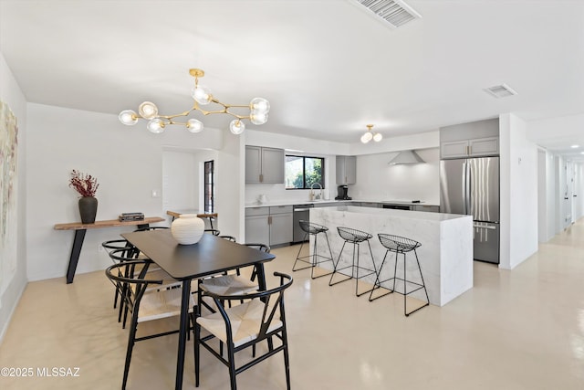 dining space with sink and a notable chandelier