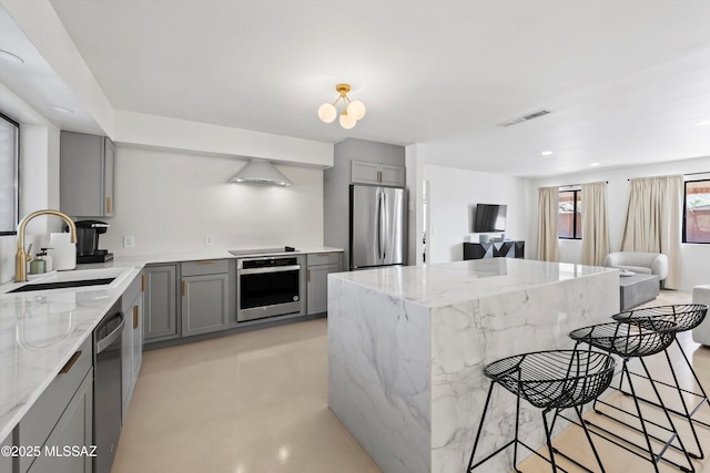 kitchen featuring sink, gray cabinets, light stone countertops, and appliances with stainless steel finishes