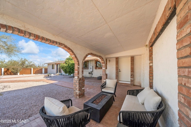 view of patio with an outdoor living space with a fire pit