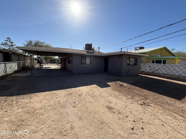 back of house featuring a carport and central AC unit