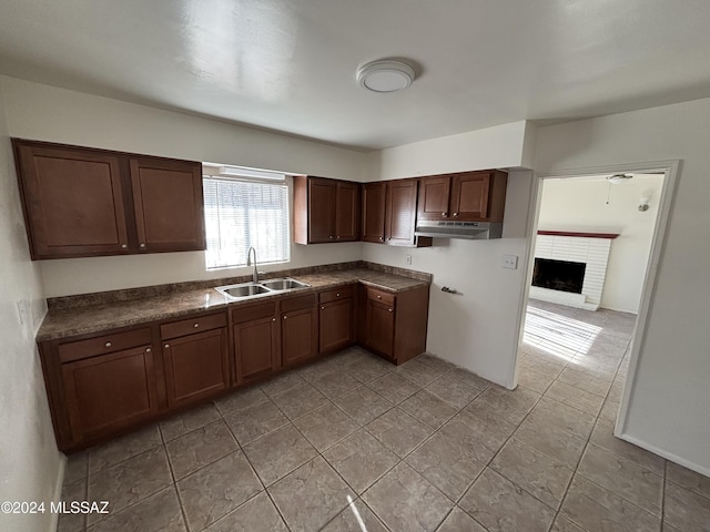 kitchen featuring sink and a brick fireplace