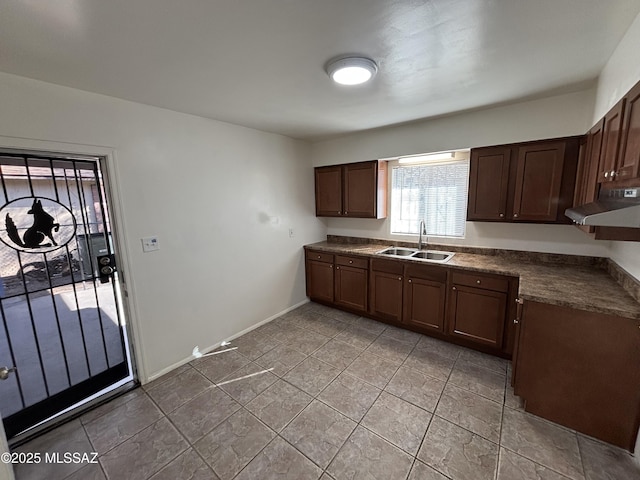 kitchen featuring sink, light tile patterned floors, and dark brown cabinets