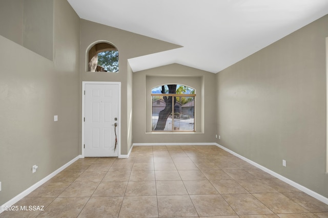 entryway with light tile patterned flooring and lofted ceiling