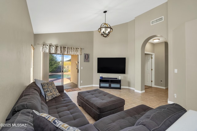 tiled living room with high vaulted ceiling and an inviting chandelier