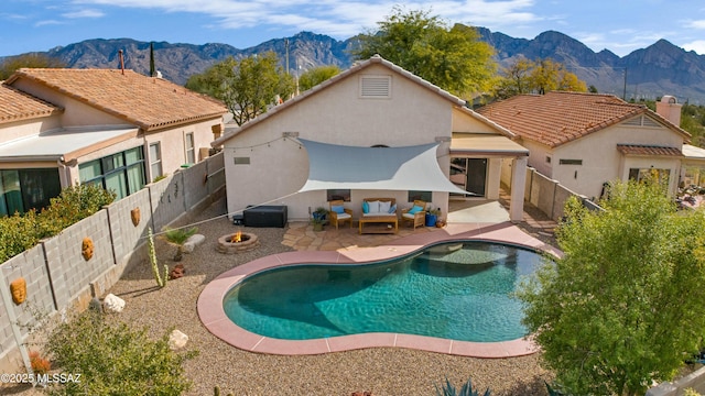 view of pool featuring a mountain view, a patio area, and an outdoor living space with a fire pit