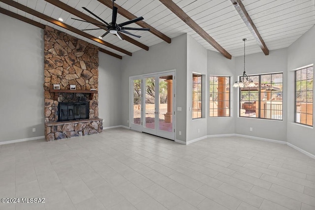 unfurnished living room with wooden ceiling, beamed ceiling, high vaulted ceiling, a fireplace, and ceiling fan with notable chandelier