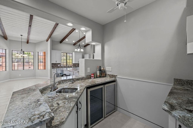 kitchen featuring beverage cooler, sink, decorative light fixtures, wooden ceiling, and white cabinetry