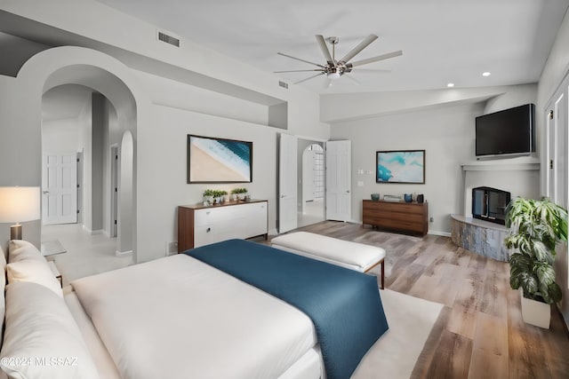 bedroom featuring ceiling fan, lofted ceiling, and light hardwood / wood-style flooring