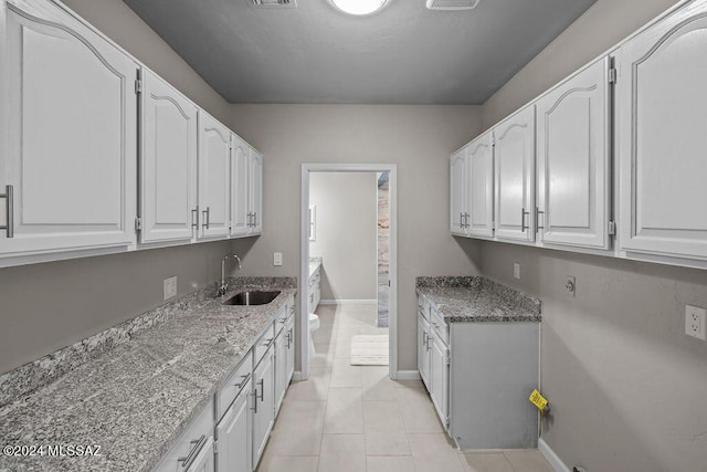 clothes washing area featuring sink and light tile patterned flooring