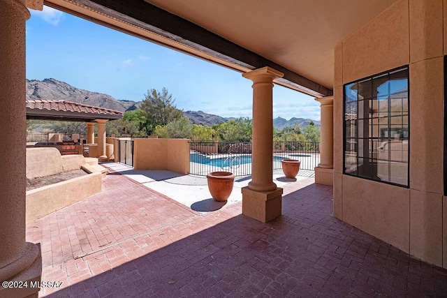 view of patio / terrace featuring a fenced in pool and a mountain view