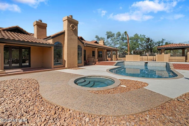 view of swimming pool featuring an in ground hot tub and a patio area