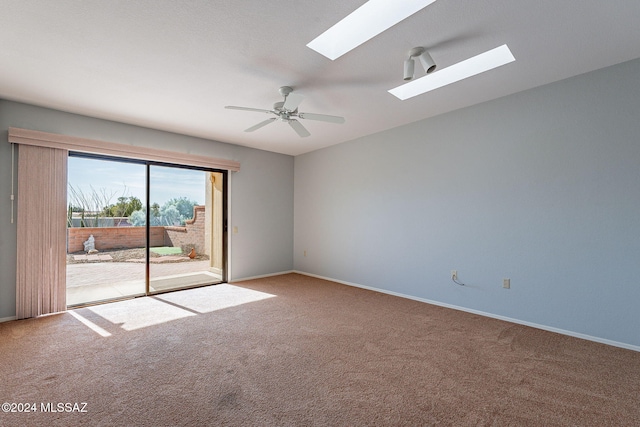 empty room with ceiling fan, light colored carpet, and a skylight