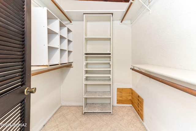 walk in closet featuring light carpet