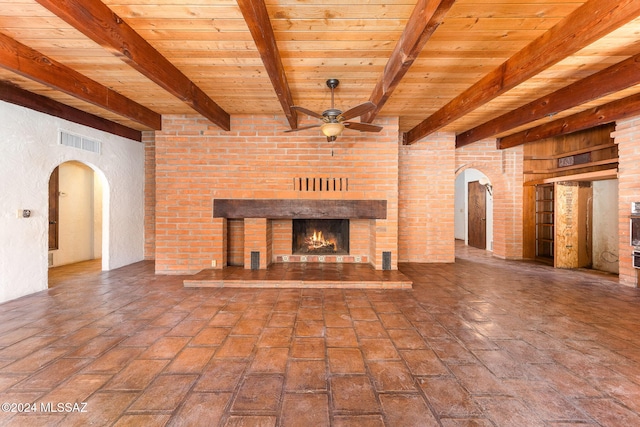 unfurnished living room featuring beamed ceiling, ceiling fan, and wood ceiling