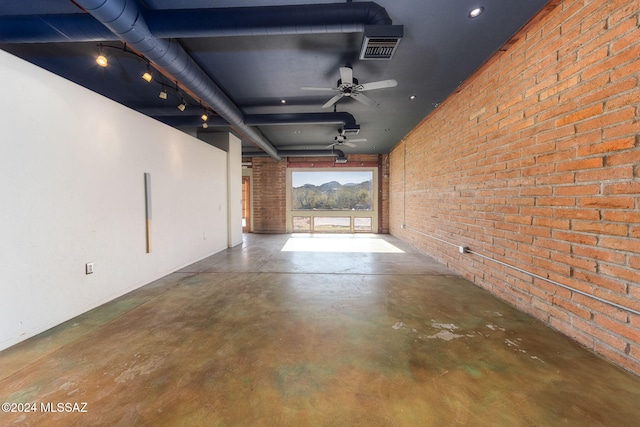 corridor with concrete floors and brick wall