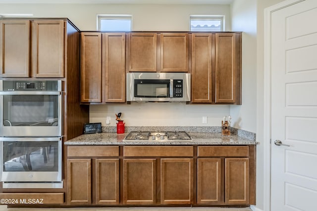 kitchen with light stone countertops and stainless steel appliances