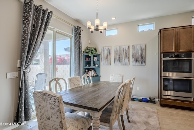 dining room featuring plenty of natural light, light tile patterned floors, and a chandelier