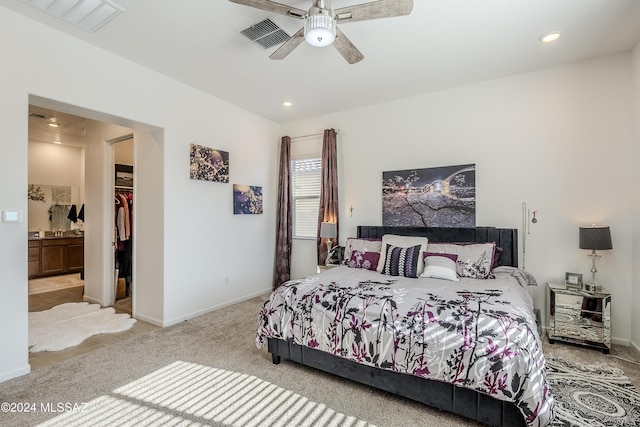 bedroom featuring a walk in closet, light carpet, a closet, and ceiling fan