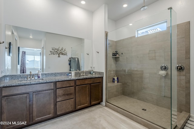 bathroom featuring a tile shower and vanity