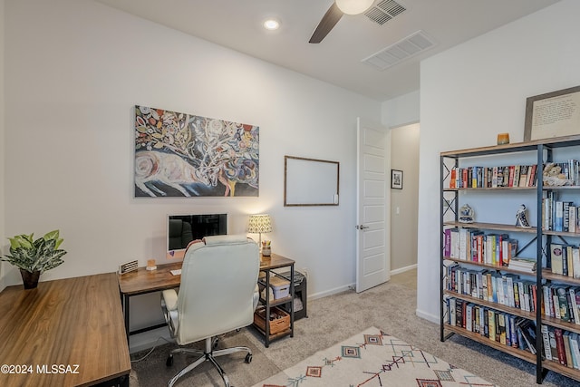 carpeted office space featuring ceiling fan