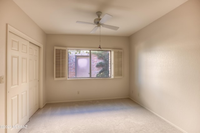 unfurnished bedroom with ceiling fan, carpet, and a closet