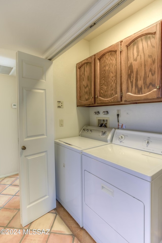 laundry room featuring light tile patterned floors, washer and clothes dryer, and cabinets