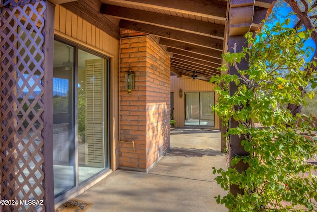 view of exterior entry with a patio area and ceiling fan