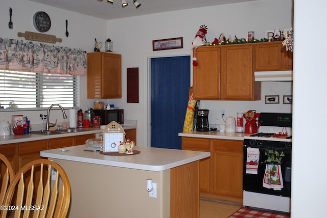 kitchen with gas stove, a center island, and sink