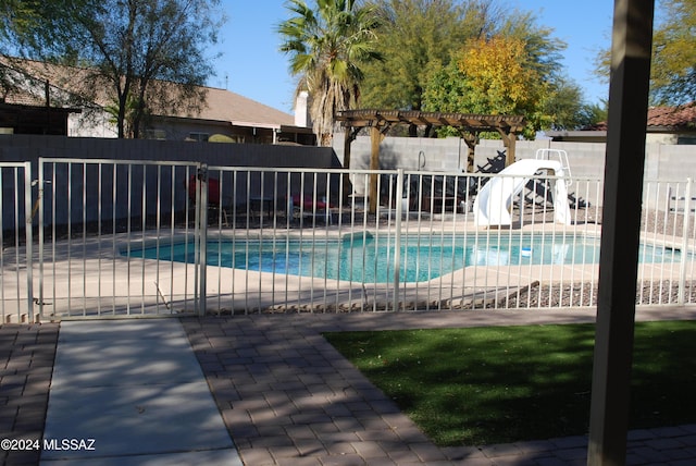 view of swimming pool with a water slide, a patio area, and a pergola