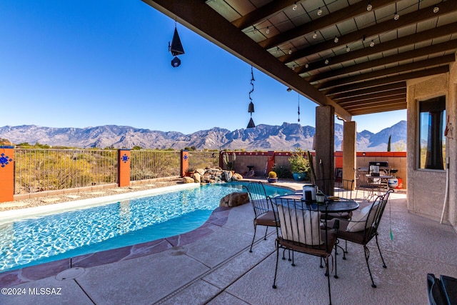 view of swimming pool featuring a mountain view and a patio area