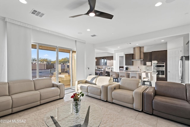 living room with sink, ceiling fan, and light tile patterned flooring