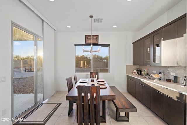 dining space with light tile patterned floors and a notable chandelier