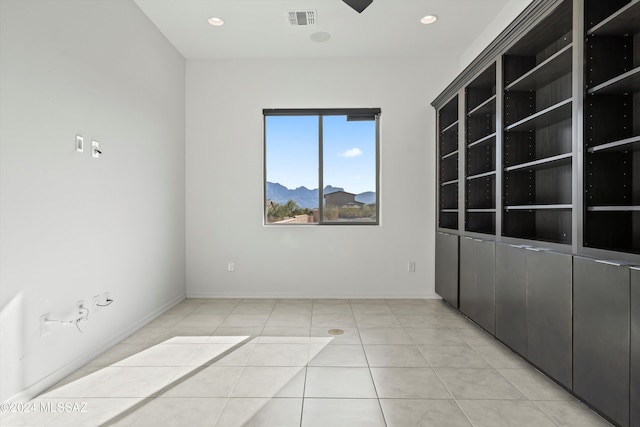 empty room featuring a mountain view and light tile patterned floors