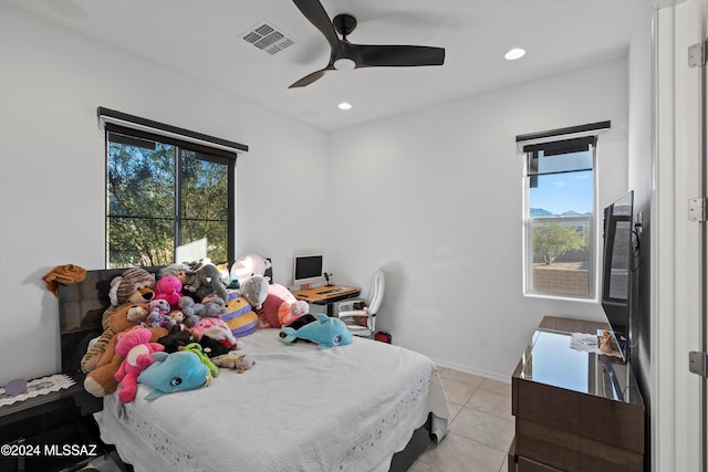 bedroom with ceiling fan, light tile patterned flooring, and multiple windows