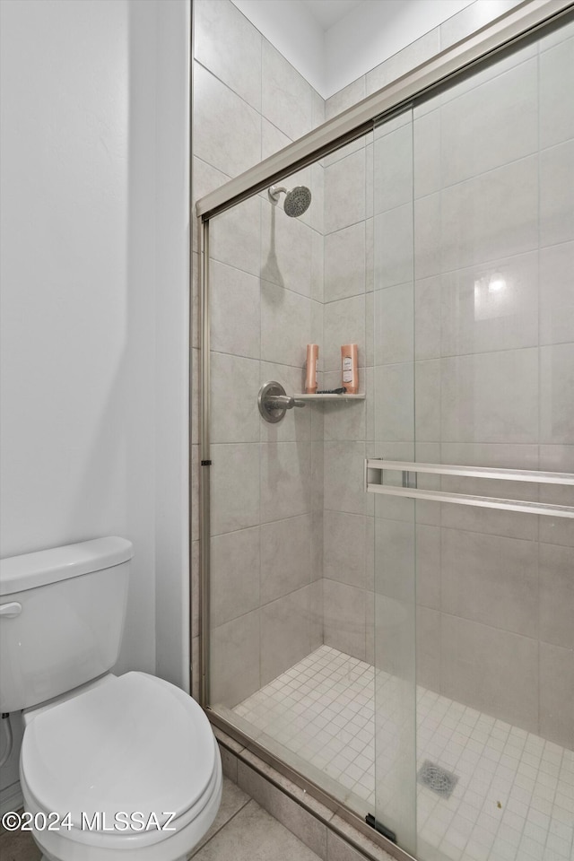 bathroom with tile patterned floors, toilet, and walk in shower