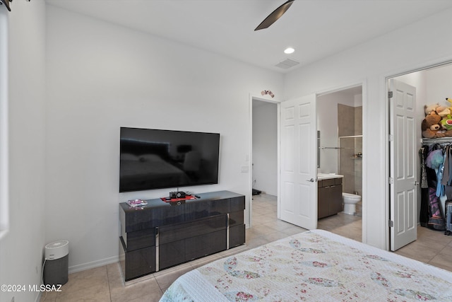 bedroom featuring ceiling fan, light tile patterned floors, and ensuite bath