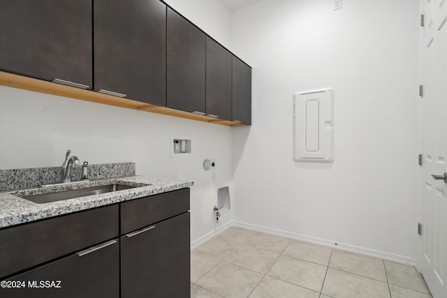 washroom with sink, cabinets, hookup for an electric dryer, hookup for a washing machine, and light tile patterned floors