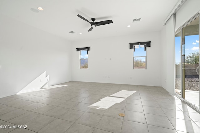 tiled spare room with ceiling fan