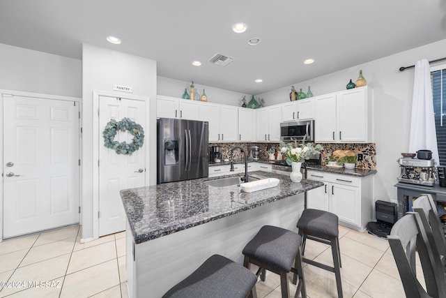 kitchen with light tile patterned flooring, white cabinetry, stainless steel appliances, and sink