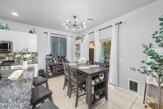 dining space featuring an inviting chandelier and light tile patterned floors